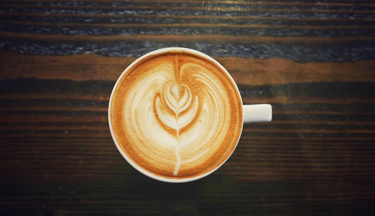Overhead latte with leaf-pattern foam art.