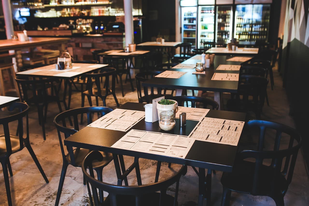Quiet cafe seating with paper menus on dark tables.